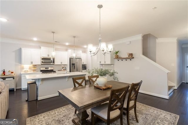 dining area featuring crown molding, dark hardwood / wood-style floors, and an inviting chandelier