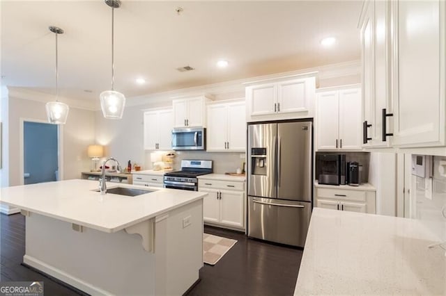 kitchen with white cabinets, appliances with stainless steel finishes, sink, and decorative light fixtures