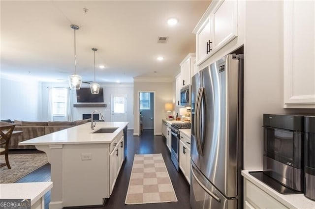 kitchen featuring white cabinets, a center island with sink, appliances with stainless steel finishes, and sink