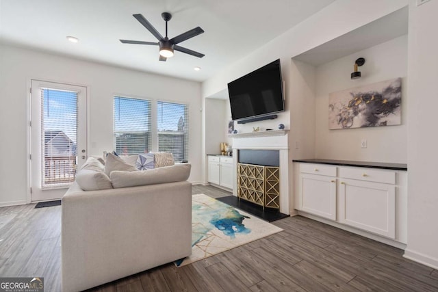 living room with ceiling fan and dark hardwood / wood-style flooring