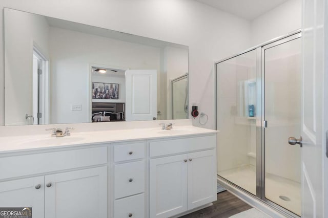 bathroom with hardwood / wood-style flooring, vanity, and walk in shower