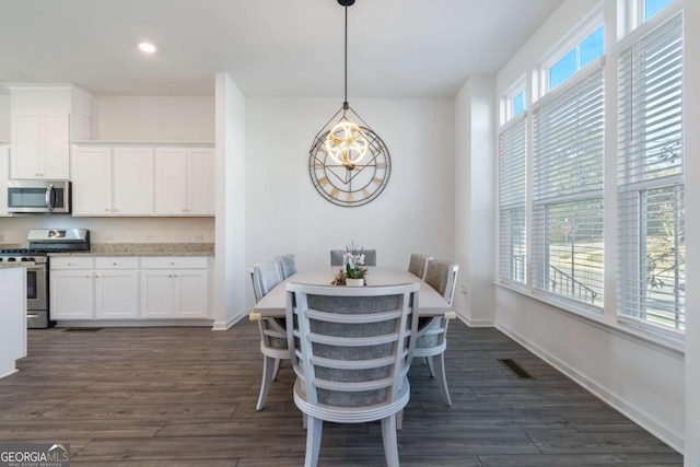 dining room featuring dark hardwood / wood-style floors and an inviting chandelier