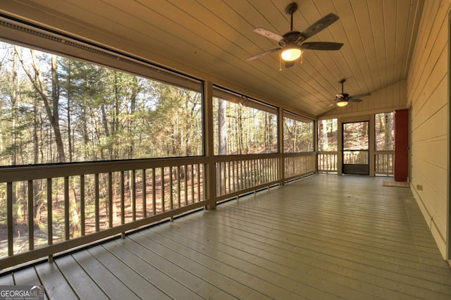 unfurnished sunroom with vaulted ceiling, wood ceiling, and a ceiling fan