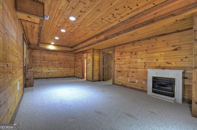 unfurnished living room with wooden ceiling, recessed lighting, wooden walls, and a glass covered fireplace