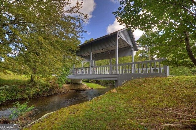 view of property exterior featuring a water view and a lawn