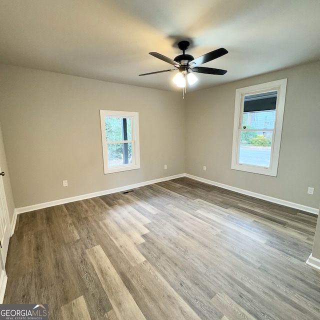 spare room with hardwood / wood-style flooring, ceiling fan, and a wealth of natural light