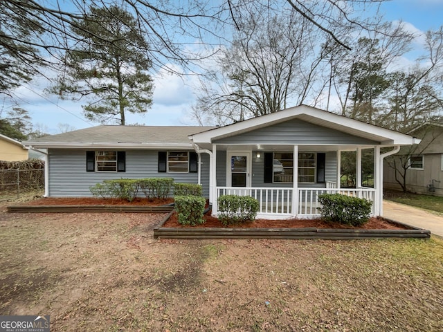 single story home featuring a porch and fence