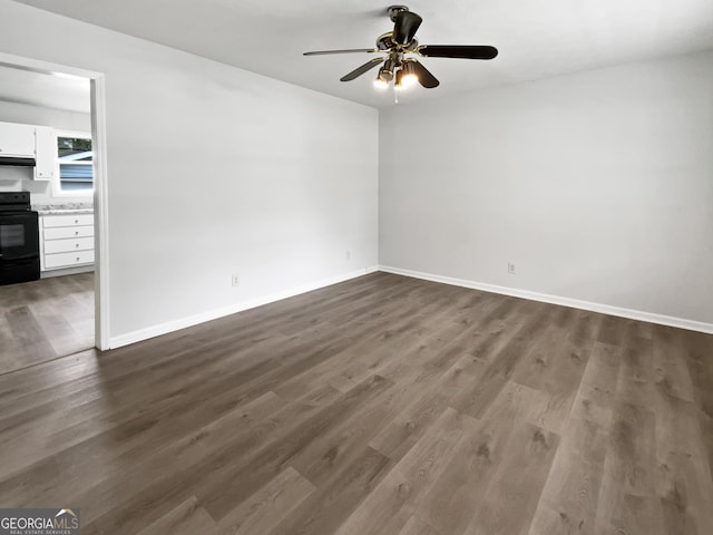 spare room featuring dark wood-style floors, ceiling fan, and baseboards