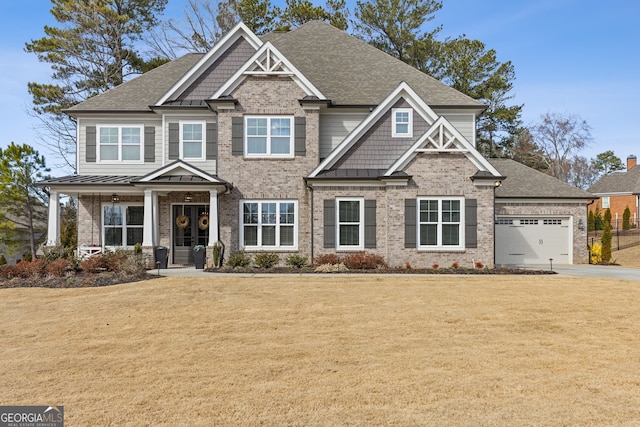 craftsman-style home with an attached garage, a standing seam roof, brick siding, and a front yard