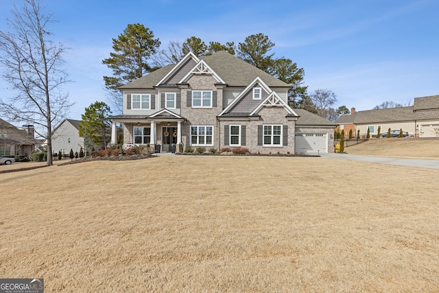 craftsman-style home with an attached garage, a porch, and a front yard