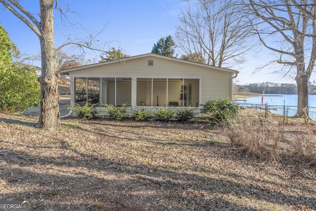 exterior space featuring a water view and a sunroom