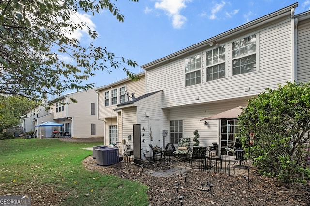 rear view of house featuring a lawn, a patio area, and central AC