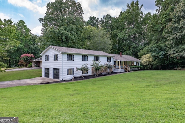 view of front of property featuring a front yard, a garage, and a porch