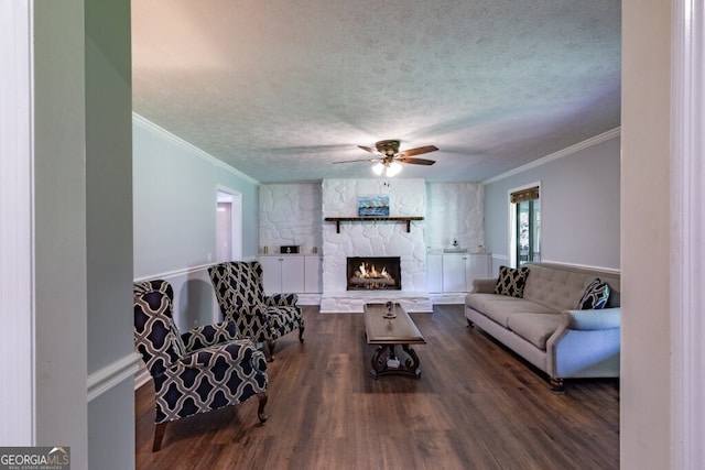 living room with a fireplace, ornamental molding, dark hardwood / wood-style floors, and a textured ceiling