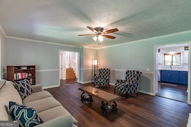 living area with ornamental molding, stairs, dark wood-style floors, a textured ceiling, and a ceiling fan
