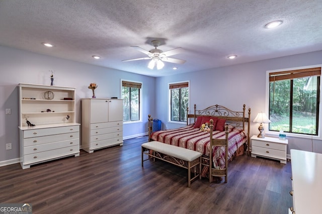 bedroom with a textured ceiling, ceiling fan, and dark hardwood / wood-style flooring