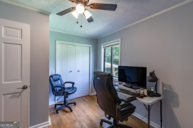 home office with ceiling fan, ornamental molding, light wood-type flooring, and a textured ceiling