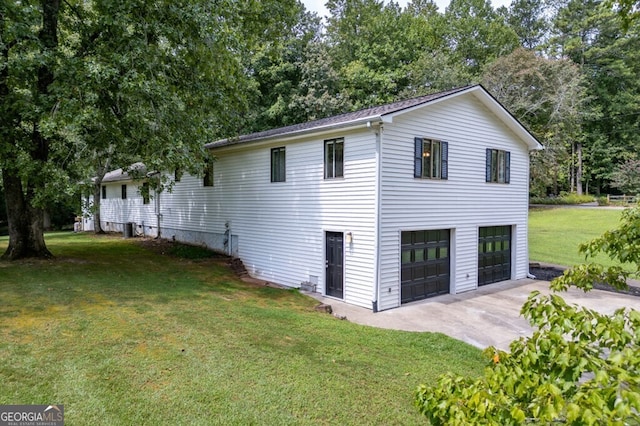 view of side of home with a garage and a lawn