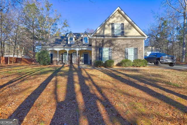 view of front of home featuring stone siding, covered porch, and a front lawn