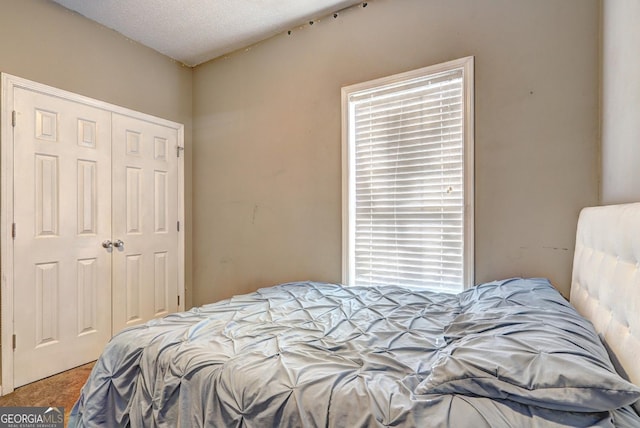 bedroom featuring carpet floors, a closet, and a textured ceiling