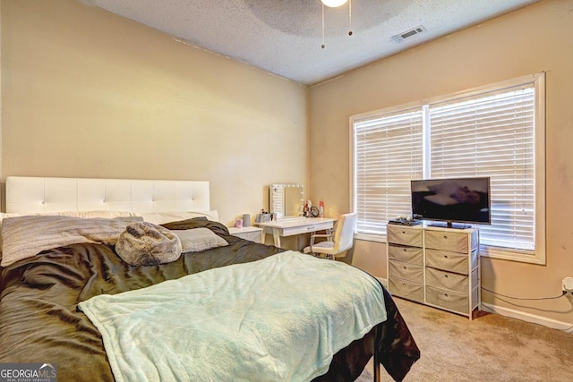 bedroom featuring light colored carpet, visible vents, a textured ceiling, multiple windows, and baseboards