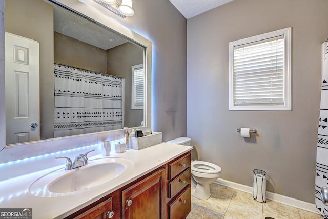 full bathroom featuring toilet, tile patterned flooring, baseboards, and vanity