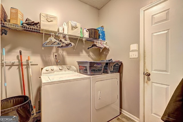 washroom with laundry area, baseboards, and separate washer and dryer