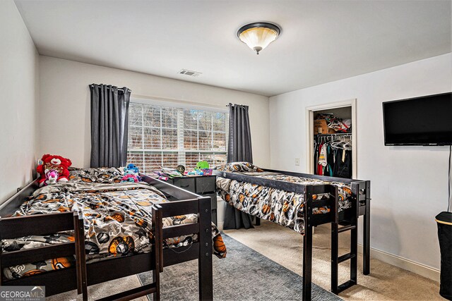 carpeted bedroom featuring a spacious closet and a closet