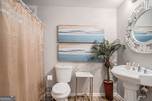 bathroom with hardwood / wood-style floors, sink, and toilet