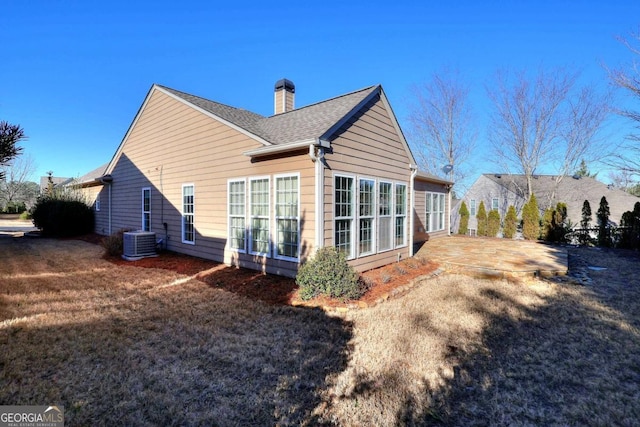 rear view of property with central air condition unit and a patio area