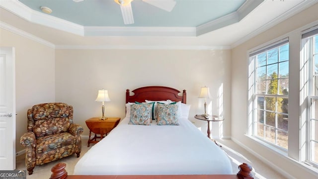 carpeted bedroom with multiple windows, crown molding, and a raised ceiling