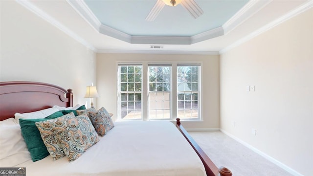 bedroom with ceiling fan, a tray ceiling, carpet floors, and ornamental molding