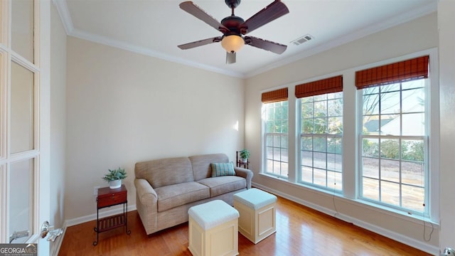 interior space featuring ceiling fan, ornamental molding, and light wood-type flooring