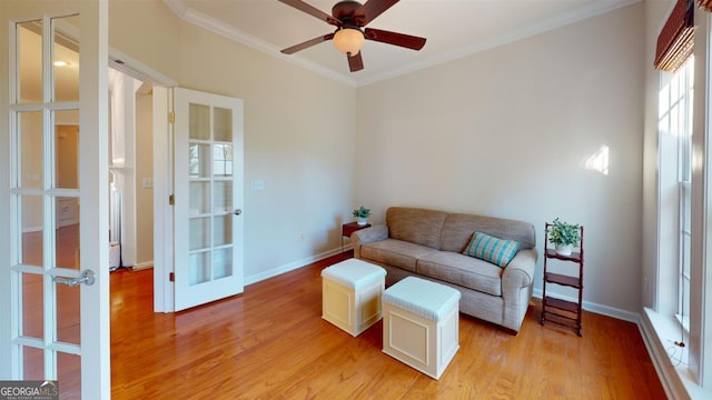 living room featuring light wood-type flooring, french doors, ornamental molding, and ceiling fan