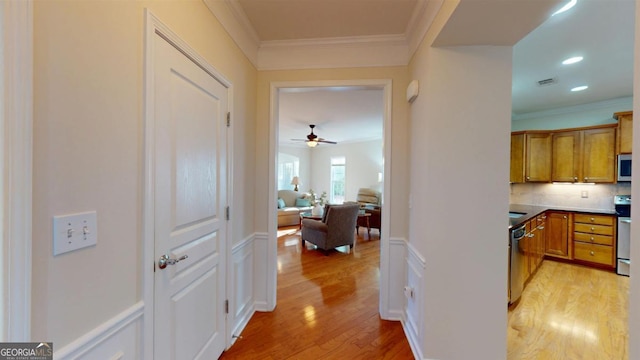 hall with ornamental molding and light hardwood / wood-style flooring