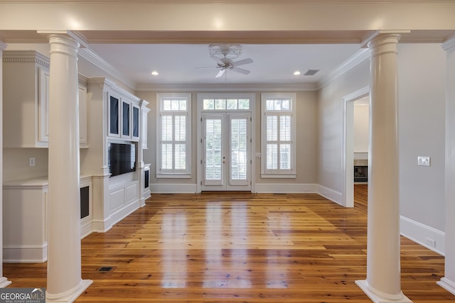 entryway with ornamental molding, ornate columns, and light hardwood / wood-style flooring