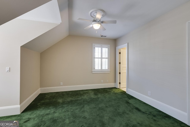 additional living space featuring vaulted ceiling, dark carpet, and ceiling fan