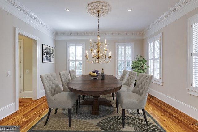 dining area with crown molding, a wealth of natural light, and hardwood / wood-style floors