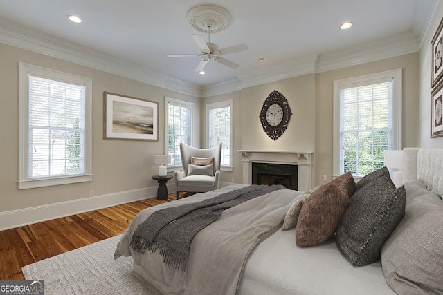 bedroom with multiple windows, hardwood / wood-style floors, and crown molding