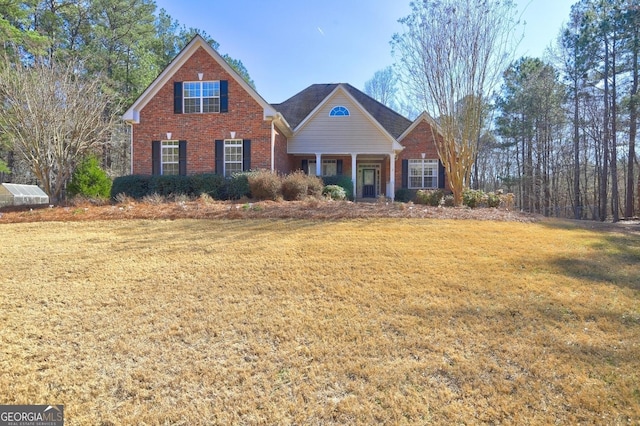 view of front of house with a front yard and brick siding