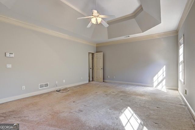 spare room with light carpet, crown molding, visible vents, and baseboards