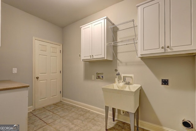 laundry room featuring cabinet space, baseboards, hookup for a gas dryer, hookup for a washing machine, and hookup for an electric dryer