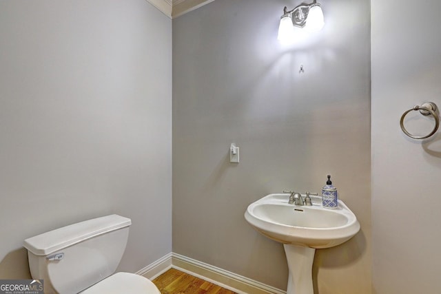 bathroom with baseboards, toilet, and wood finished floors