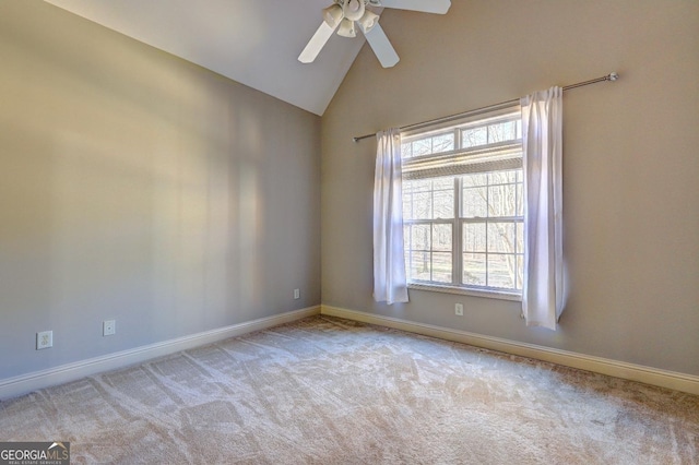 spare room with light colored carpet, vaulted ceiling, and baseboards