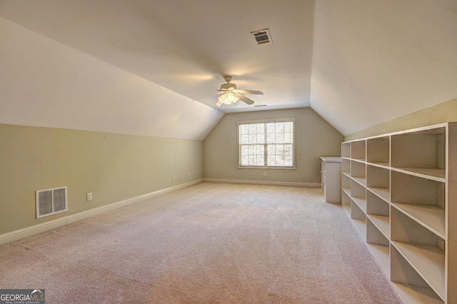 additional living space featuring lofted ceiling, baseboards, visible vents, and light colored carpet