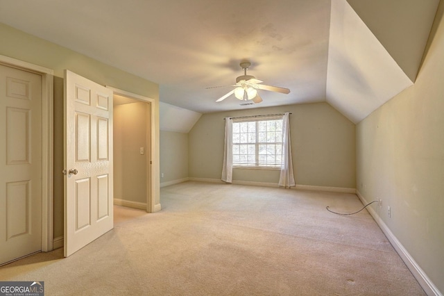 bonus room featuring lofted ceiling, baseboards, a ceiling fan, and light colored carpet