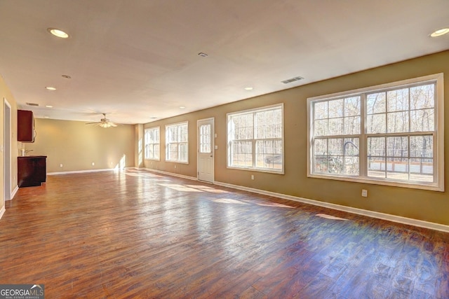 unfurnished living room featuring baseboards, visible vents, ceiling fan, dark wood-type flooring, and recessed lighting