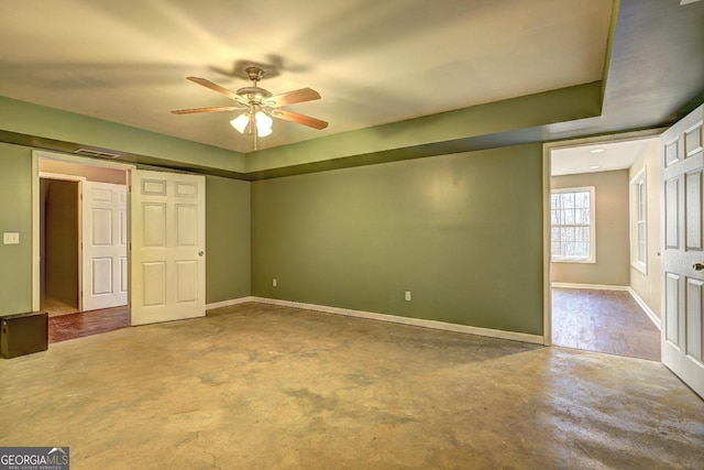 unfurnished bedroom featuring concrete flooring, visible vents, baseboards, and a ceiling fan