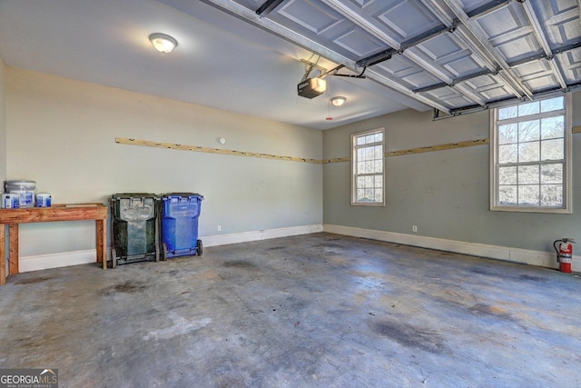 garage featuring a garage door opener and baseboards