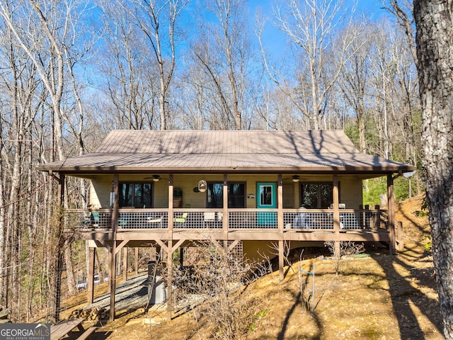 rear view of property featuring ceiling fan, a fire pit, a deck, and central AC unit